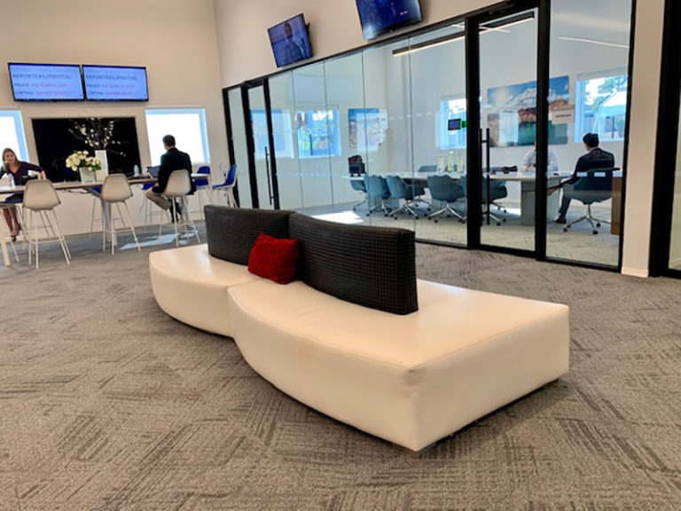 Somers furniture rental installation of White serpentine sectional seating with black accents at telemundo grand opening