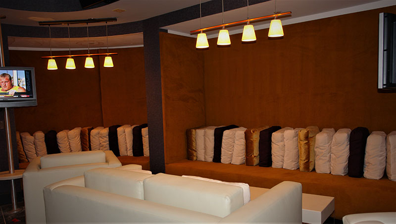Gold velvet high back upholstered banquettes serve as lounge seating at Lagasse’s Stadium