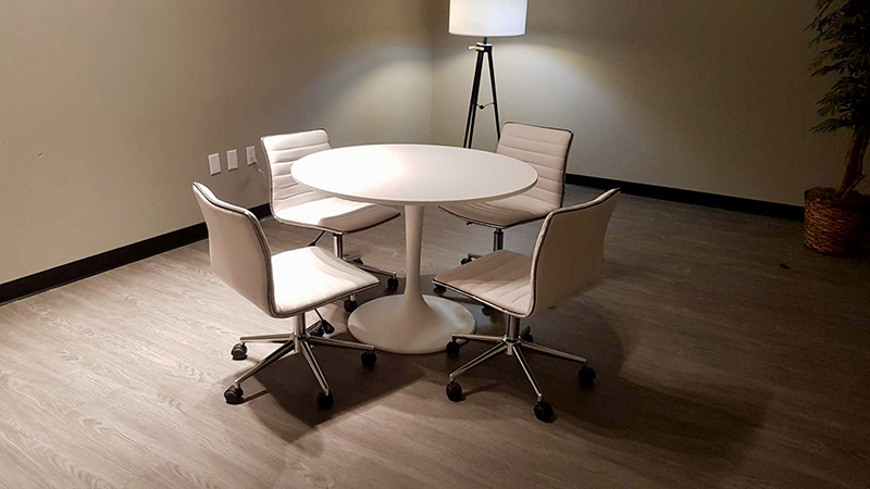 meeting room at World Market Center in Las Vegas with round conference table and low back office chairs and a standing lamp